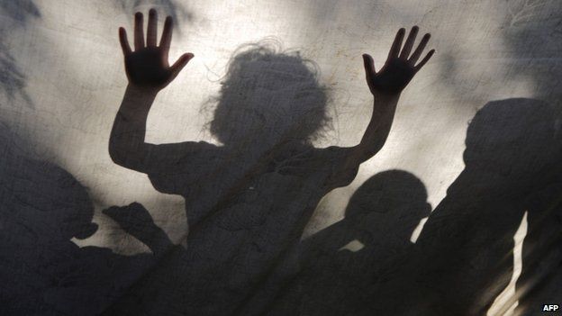 Palestinian children are seen behind a sheet covering a makeshift tent in Gaza City (27 July 2014)