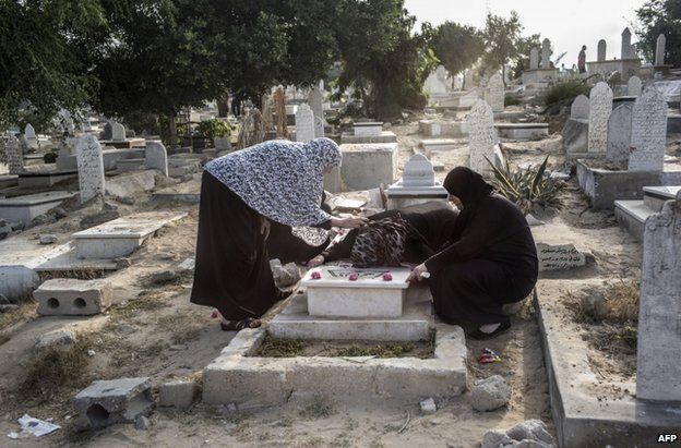 Palestinian women visit a grave in Gaza, 28 July