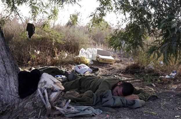 An Israeli soldier sleeps on the border with Gaza, 28 July