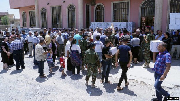 Iraqi Christian refugees receive aid in Hamdaniya, east of Mosul, 20 July 14