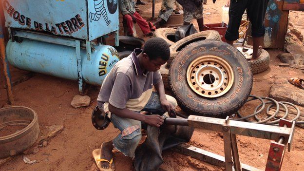 A young man fixes a punctured wheel in Bambari, CAR - July 2014
