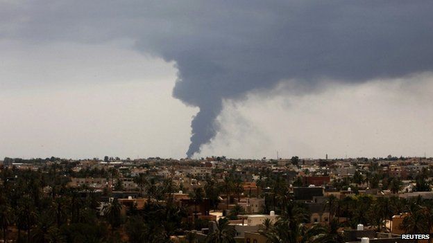 Plumes of smoke rise in the sky after a rocket hit a fuel storage tank near the airport road in Tripoli, during clashes between rival militias on 28 July 2014.