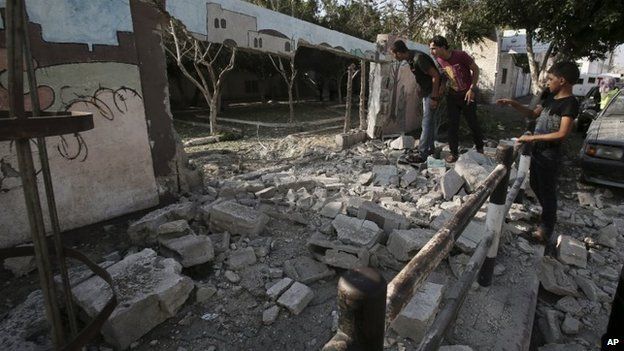 Palestinians inspect the destroyed wall of Shifa hospital after an air strike, in Gaza, in the northern Gaza Strip, 28 July 2014