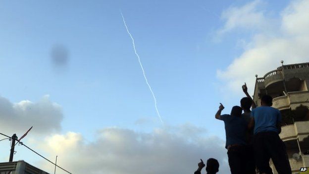 Palestinians watch the smoke trail of a missile fired by Palestinian militants from inside northern Gaza Strip, 28 July 2014