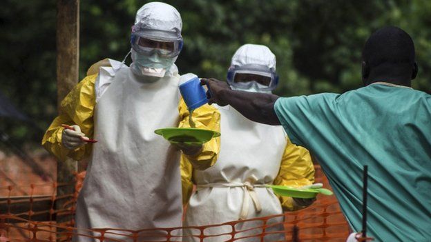 Medical staff working prepare to bring food to patients kept in an isolation area at an Ebola treatment centre in Kailahun, eastern Sierra Leone on 20 July 2014