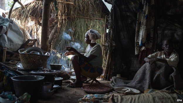 A displaced Christian woman cooks dinner at the largest displacement site located outside the French military base in Bambari, Central African Republic - 27 July 2014