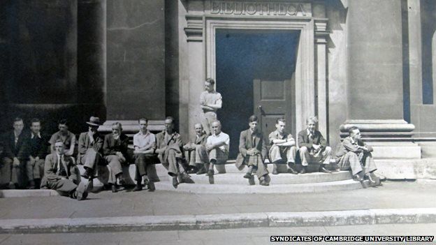 Workers rest on the steps of the old library