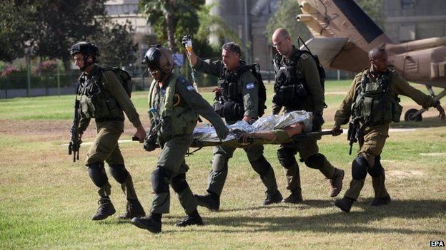Israeli troops carry soldier wounded in Gaza, 30 July
