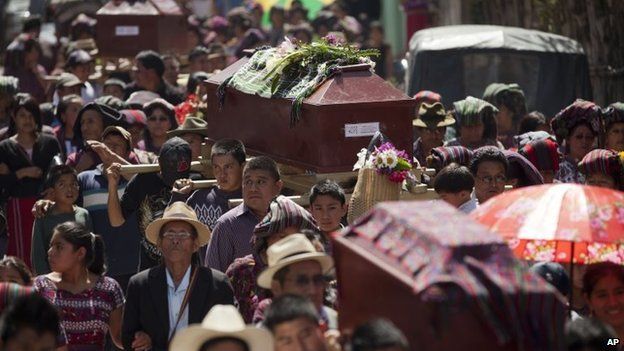 Relatives carry coffins of some of the 31 villagers massacred during the civil war in 1982, in Santa Maria Nebaj, Guatemala, 30 July 2014