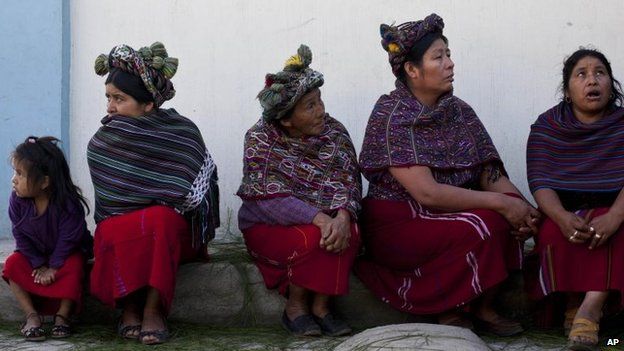 Women gather before taking part in the burial of 31 villagers massacred during the civil war in 1982 in Santa Maria Nebaj, Guatemala, 30 July 2014