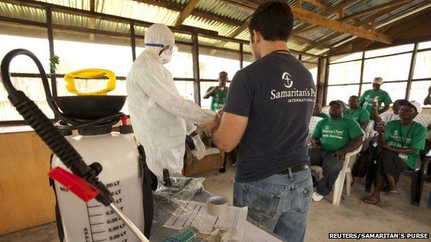 A member of the Samaritan's Purse medical staff demonstrates personal protective equipment to educate volunteers on the Ebola virus in Liberia