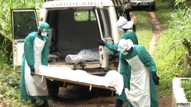 Health workers carry the body of an Ebola virus victim in Kenema, Sierra Leone, 25 June 2014