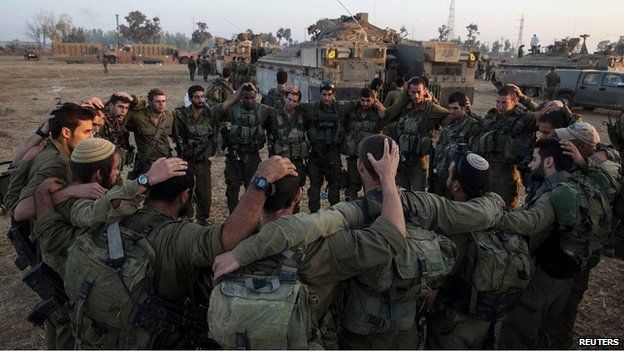 Israeli troops in a circle before entering Gaza, 30 July 2014