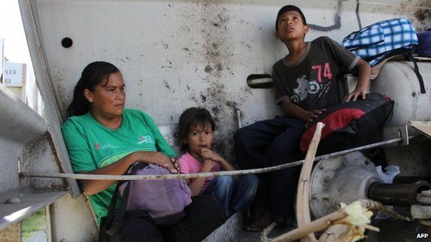 A Central American immigrant and her children sit inside La Bestia in Arriaga on 16 July, 2014.