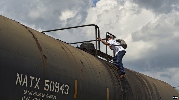 A Central American migrant gets on La Bestia cargo train in Apizaco on 22 July, 2014