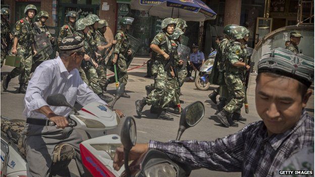 Chinese soldiers march past near the Id Kah Mosque, China's largest, on 31 July 2014 in Kashgar, China