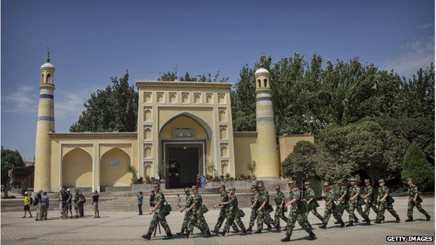 Chinese soldiers march in front of the Id Kah Mosque, China's largest, on 31 July 2014 in Kashgar, China