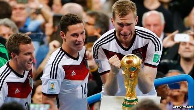 Members of Germany's winning World Cup football team with trophy