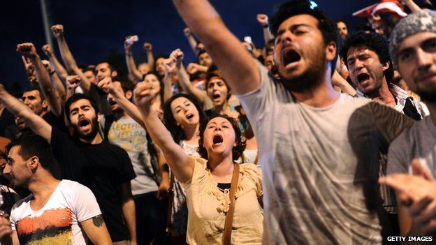 Turkish anti government protesters chant slogans at the entrance of Gezi park in July 2013
