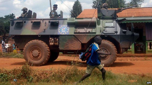 Sangaris troops patrol in an armoured personnel carrier as a schoolboy passes by, in Bangui, the Central African capital, on 13 July 2014