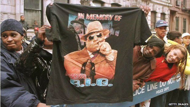man holds up T-shirt in memory of BIG