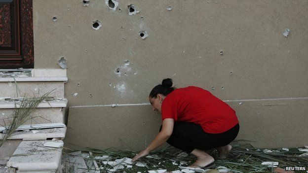 An Israeli woman surveys the damage after a rocket fired by Palestinian militants in Gaza landed in the southern town of Kiryat Gat