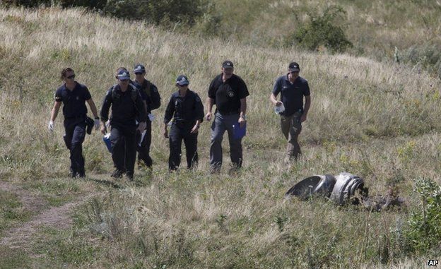 Australian experts examine the area of the Malaysia Airlines Flight 17 plane crash near the village of Grabove, east Ukraine, 1 August