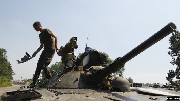 A Ukrainian soldier cleans up his Armoured fighting vehicle as he guards a checkpoint outside the eastern Ukrainian village of Nikishyne (1 August 2014)