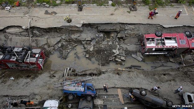 Damaged vehicles lie on the road after gas explosions in Kaohsiung - 1 August 2014
