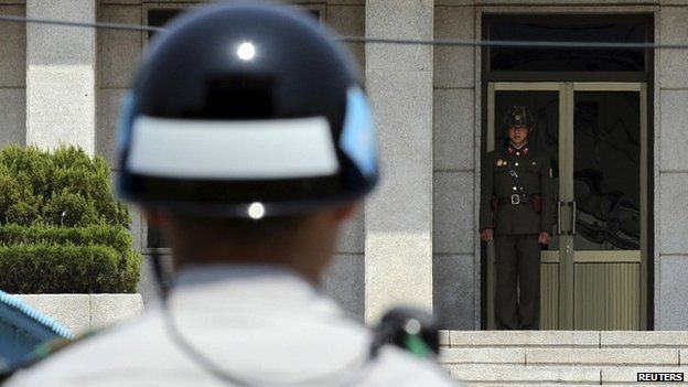 A North Korea soldier looks towards a South Korea soldier at the border - 14 May 2014