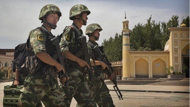 Chinese soldiers march in front of China's largest mosque in the city of Kashgar in Xinjiang - 31 July 2014