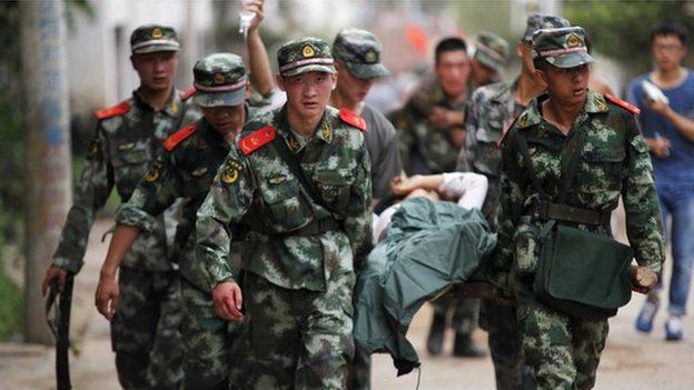 Paramilitary policemen carry an injured resident on a stretcher after an earthquake hit Ludian county of Zhaotong, Yunnan province August 3, 2014