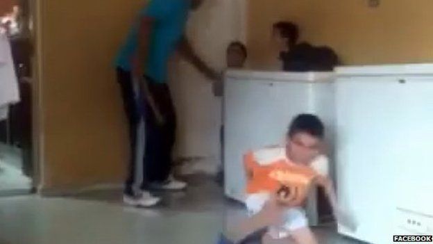 Still of the video showing a Egyptian man beating young orphans