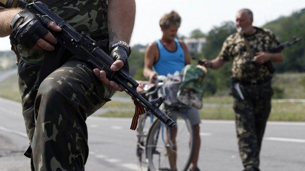 Armed pro-Russian separatists stand guard at a checkpoint in the settlement of Yasynuvata outside Donetsk, on 5 August 2014.