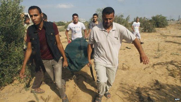 Palestinians remove a body found under rubble in Rafah, southern Gaza, 5 Aug