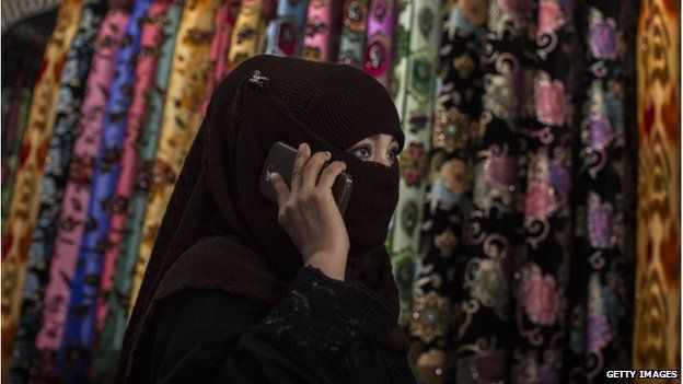 An Uighur woman wears a veil as she shops at a local market on 2 August 2014 in Kashgar, Xinjiang Province, China.