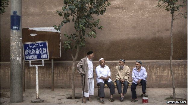 Uighur men chat before evening prayers outside a mosque on 30 July 2014 in old Kashgar, Xinjiang Province, China