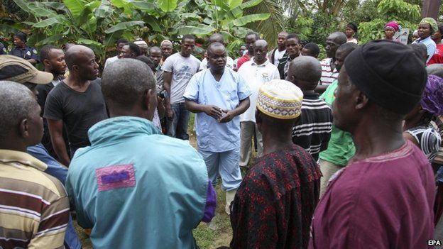 A Liberian nurse (C) addresses family members of dead Ebola victims before burial on the outskirts of Monrovia (6 August 2014)