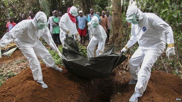 Liberian nurses carry the body of an Ebola victim on the way to bury them in the Banjor Community on the outskirts of Monrovia, Liberia, on 6 August 2014.
