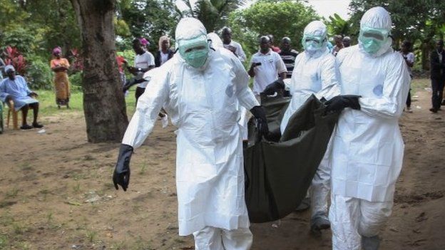 Liberian nurses carry the body of an Ebola victim from a home in the Banjor Community on the outskirts of Monrovia, Liberia - 6 August 2014