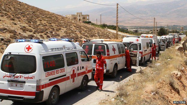 A convoy of Red Cross vehicles evacuate casualties from the Sunni Muslim border town of Arsal, in eastern Bekaa Valley