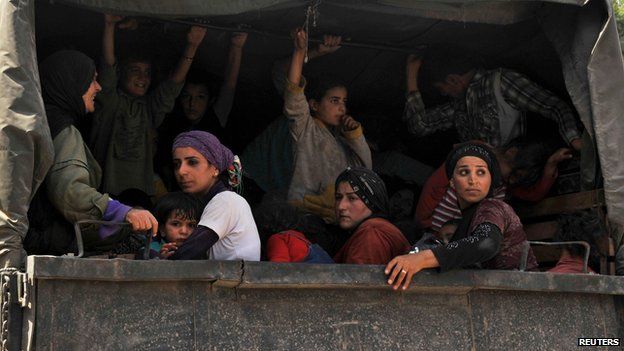 Syrian refugees sit in a Lebanese Army truck after fleeing the violence in Arsal, in Al-Labwa in eastern Bekaa Valley