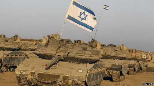 Israeli tanks are seen in a staging area near the border with the Gaza Strip (7 August 2014)