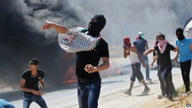 Palestinian protesters throw rocks at Israeli troops near the West Bank town of Nablus (8 August 2014)