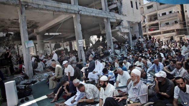 People attend Friday prayers at the site of a mosque that was bombed in Gaza (8 August 2014)