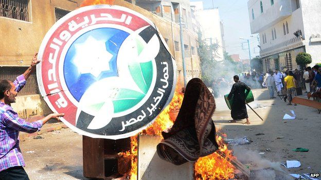 A man burns the logo of the Freedom and Justice Party (FJP) in Cairo on 23 August 2013