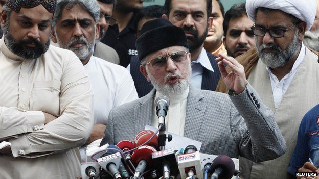 Muhammad Tahirul Qadri, Sufi cleric and leader of political party Pakistan Awami Tehreek (PAT) gestures as he addresses a news conference outside his residence in Lahore August 9