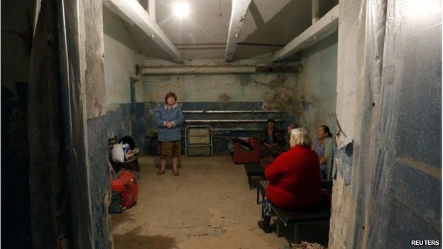 Local residents chat inside a bomb shelter where they are seeking refuge during what they say is shelling in Donetsk August 9