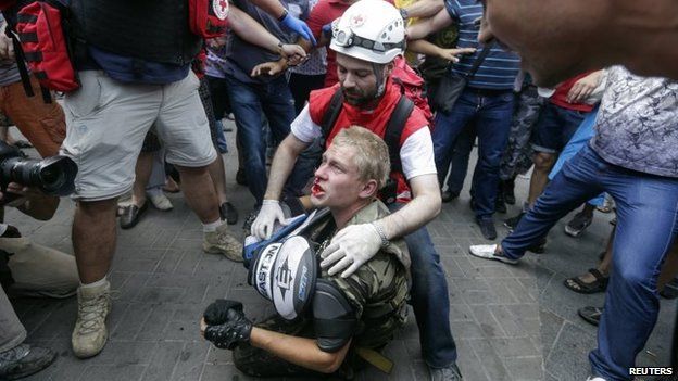 A protester receives medical treatment after clashes with municipal workers and volunteers at Independence Square in Kiev August 9