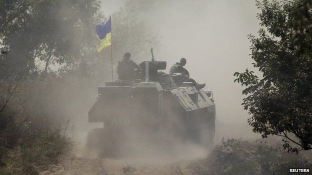 Ukrainian servicemen ride atop an armoured personnel carrier as they patrol an area near Donetsk on 11 August 2014.